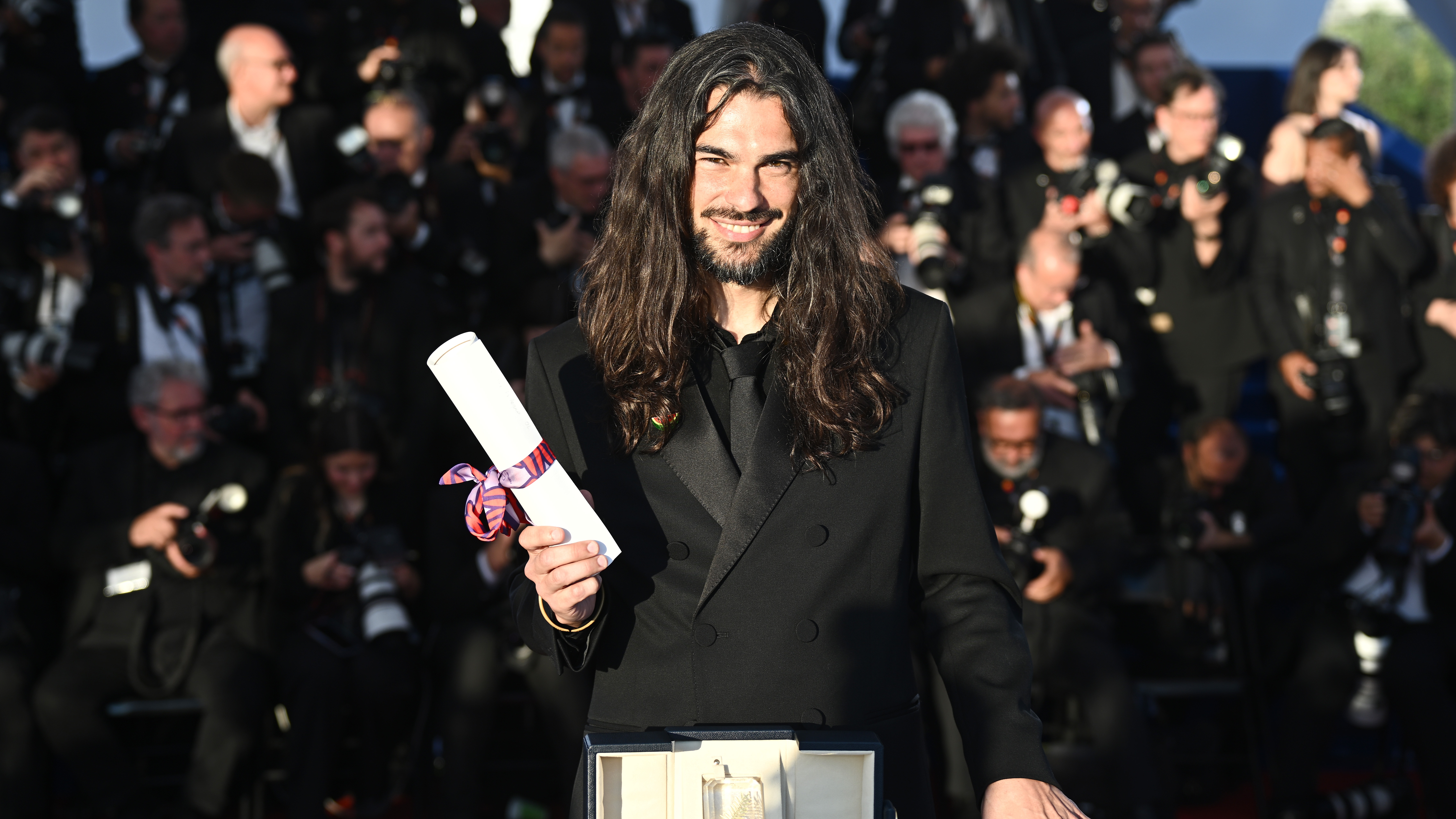 Oliver Laxe poses with the Jury Prize for Sir&amp;#257;t during the Palme D'Or winners photocall