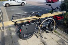 RemiDemi XL by Benno outside a popular DIY store with Long lengths of wood strapped down either side of it.