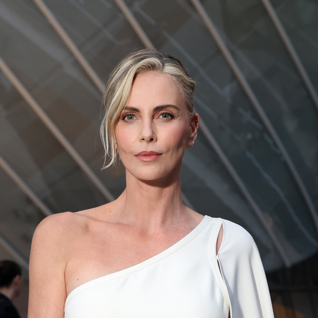 Charlize Theron in a white off-the-shoulder dress with minimal makeup and an updo.