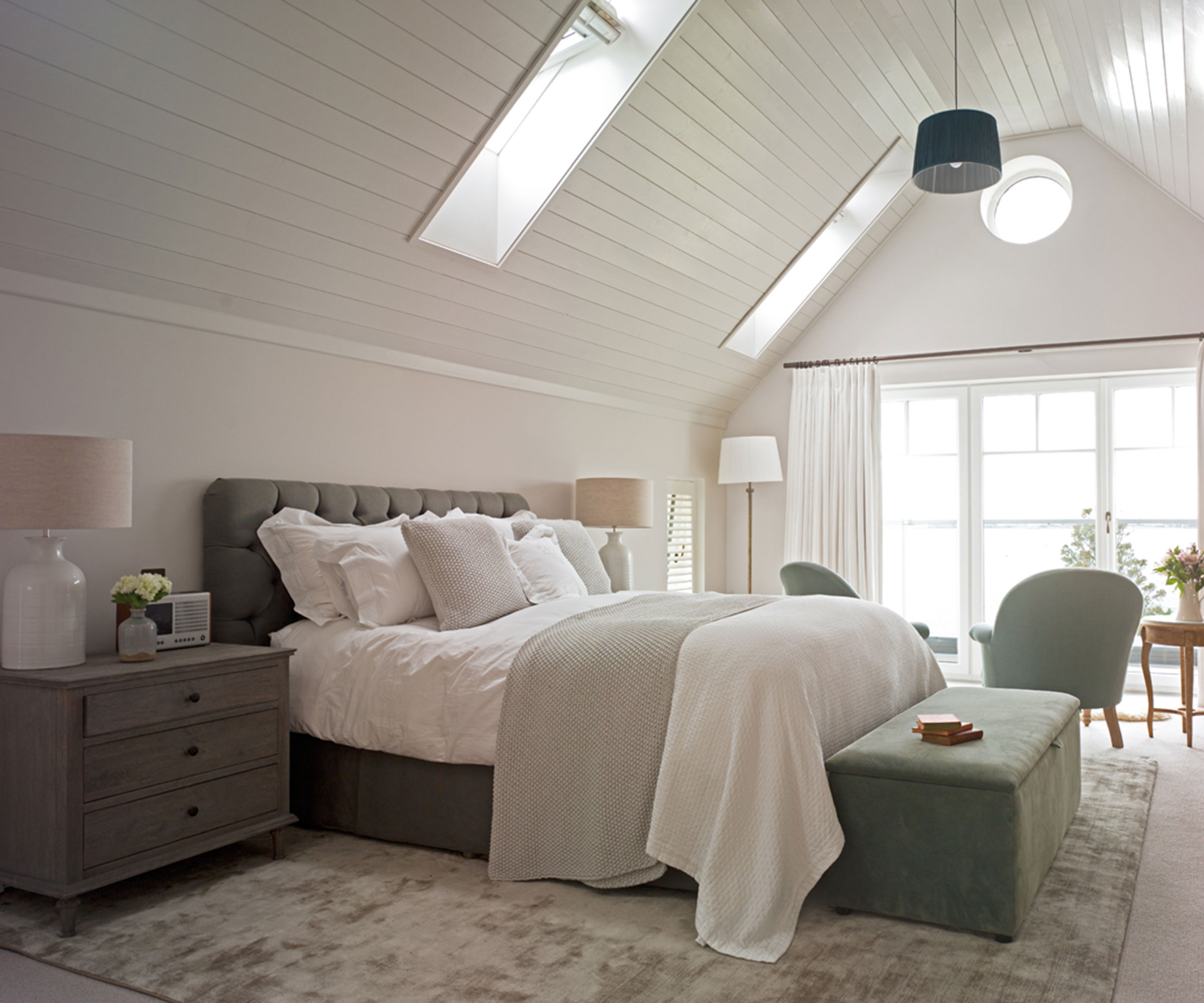 large master bedroom with vaulted ceiling and full height glazing and rooflights
