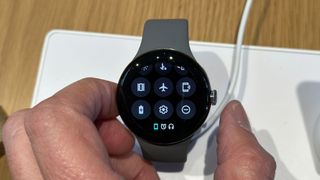 En person holder en Google Pixel Watch mellom fingrene