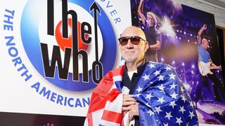 Pete Townshend drapes a flag of the United States over his shoulders at the Iconic Images Gallery in London during a special announcement about The Who. Picture date: Thursday May 8, 2025.