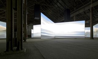 Labyrinthine arrangement of screens, which guide visitors like the current of a winding stream