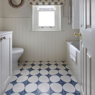 blue and white bath floor tiles in pale bathroom