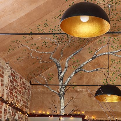 room with brown tree designed roof wall and ceiling lamps 