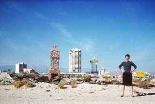 Pictured: Denise Scott Brown in the Las Vegas desert with the Strip behind her, 1966