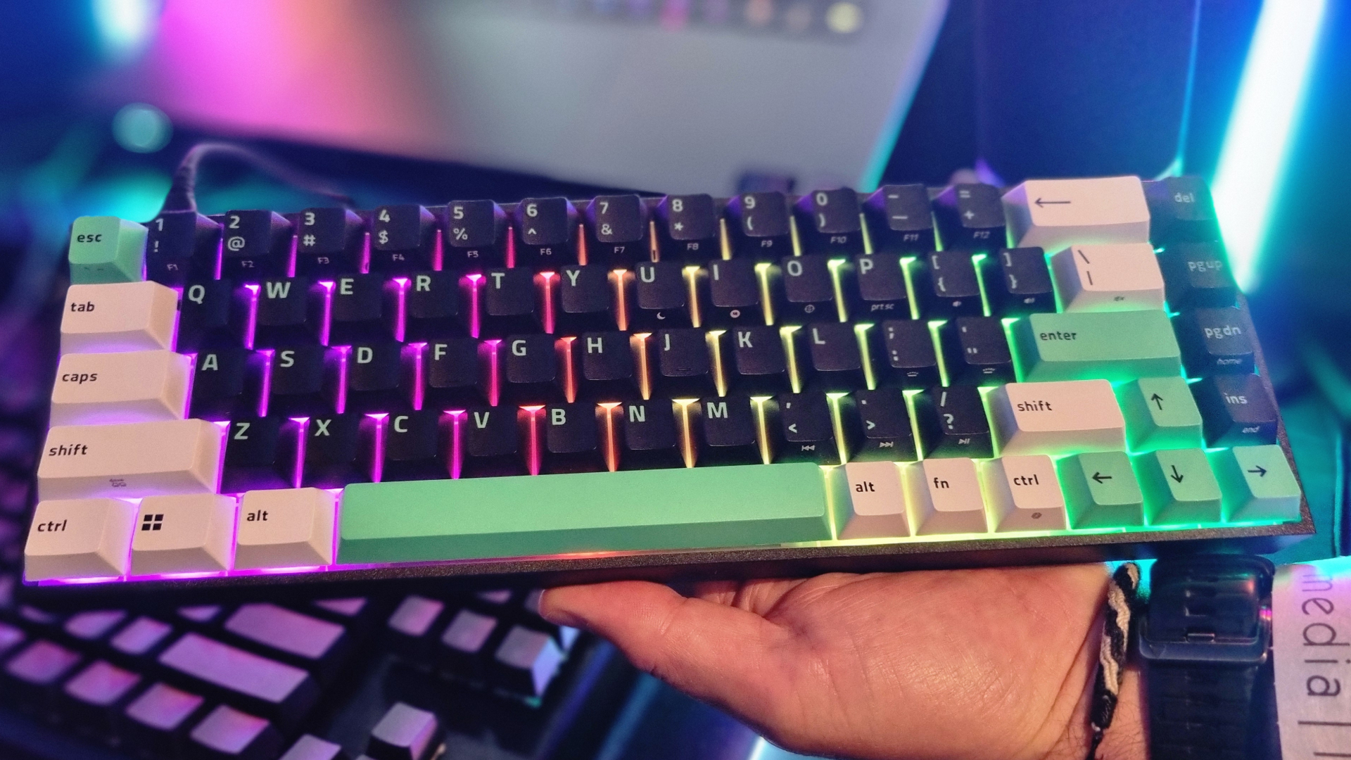 A Razer Reclusa X Mini 65% gaming keyboard lit up with RGB lighting in the Razer booth at Gamescom 2026