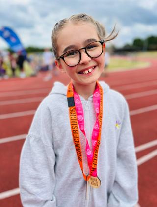 Skye looking happy with a Cancer Sucks medal around her neck