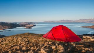 A red tent pitched at the Summit of Ben Lora