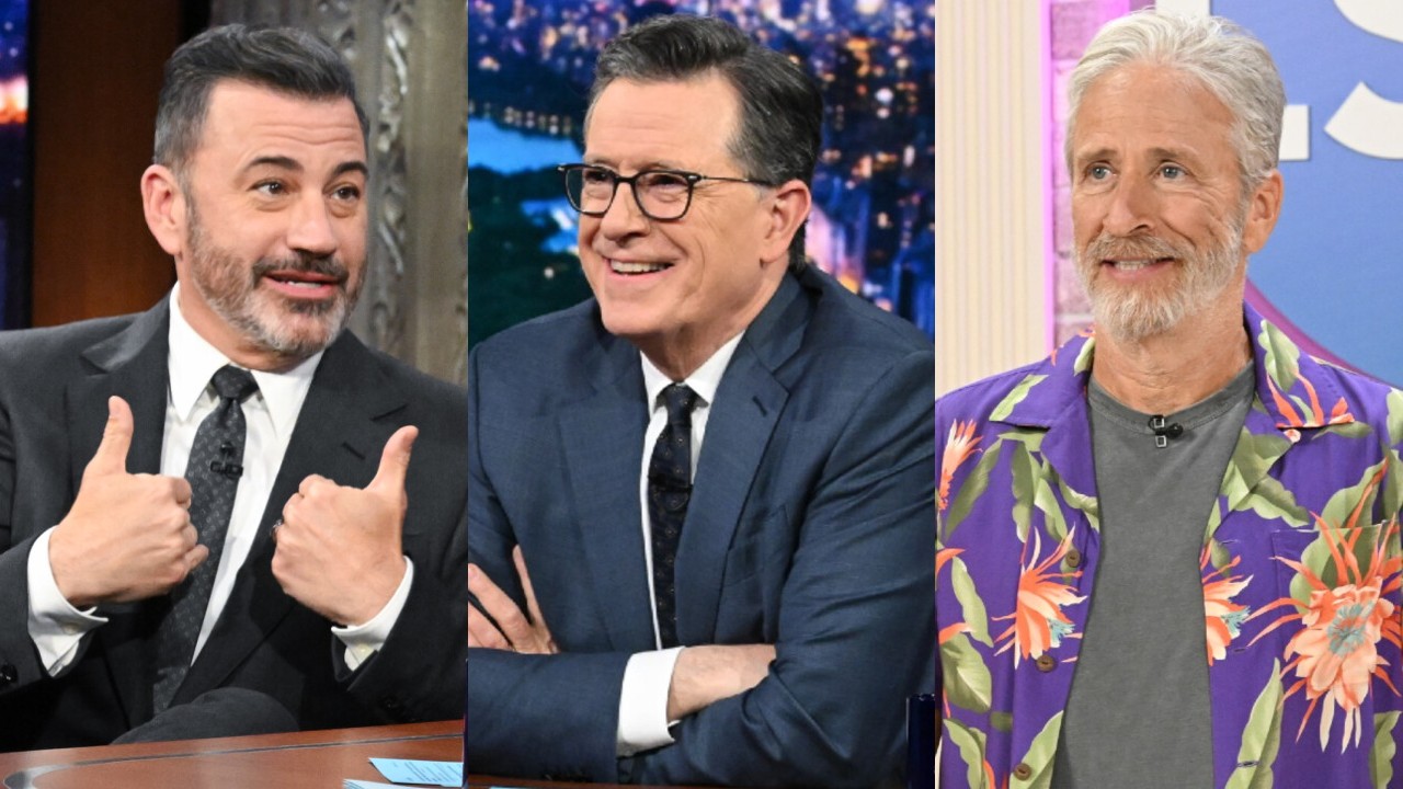 From left to right: Jimmy Kimmel giving two thumbs up, Stephen Colbert crossing his arms and smiling and Jon Stewart wearing a floral top. All on The Late Show.