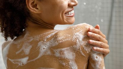 Best body washes - woman with lather all over her back in the shower - gettyimages 1451831969