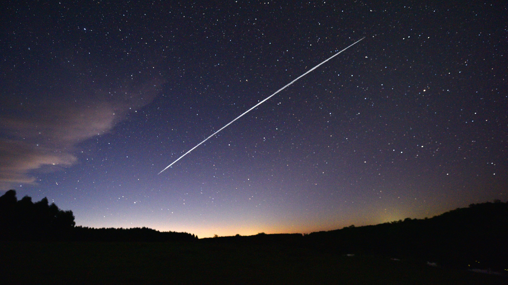A long-exposure photograph showing the trail of a group of SpaceX's Starlink satellites passing over Uruguay