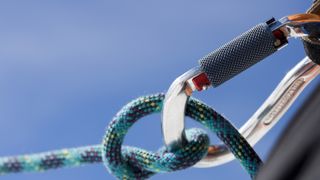 Carabiner and climbing rope against blue sky
