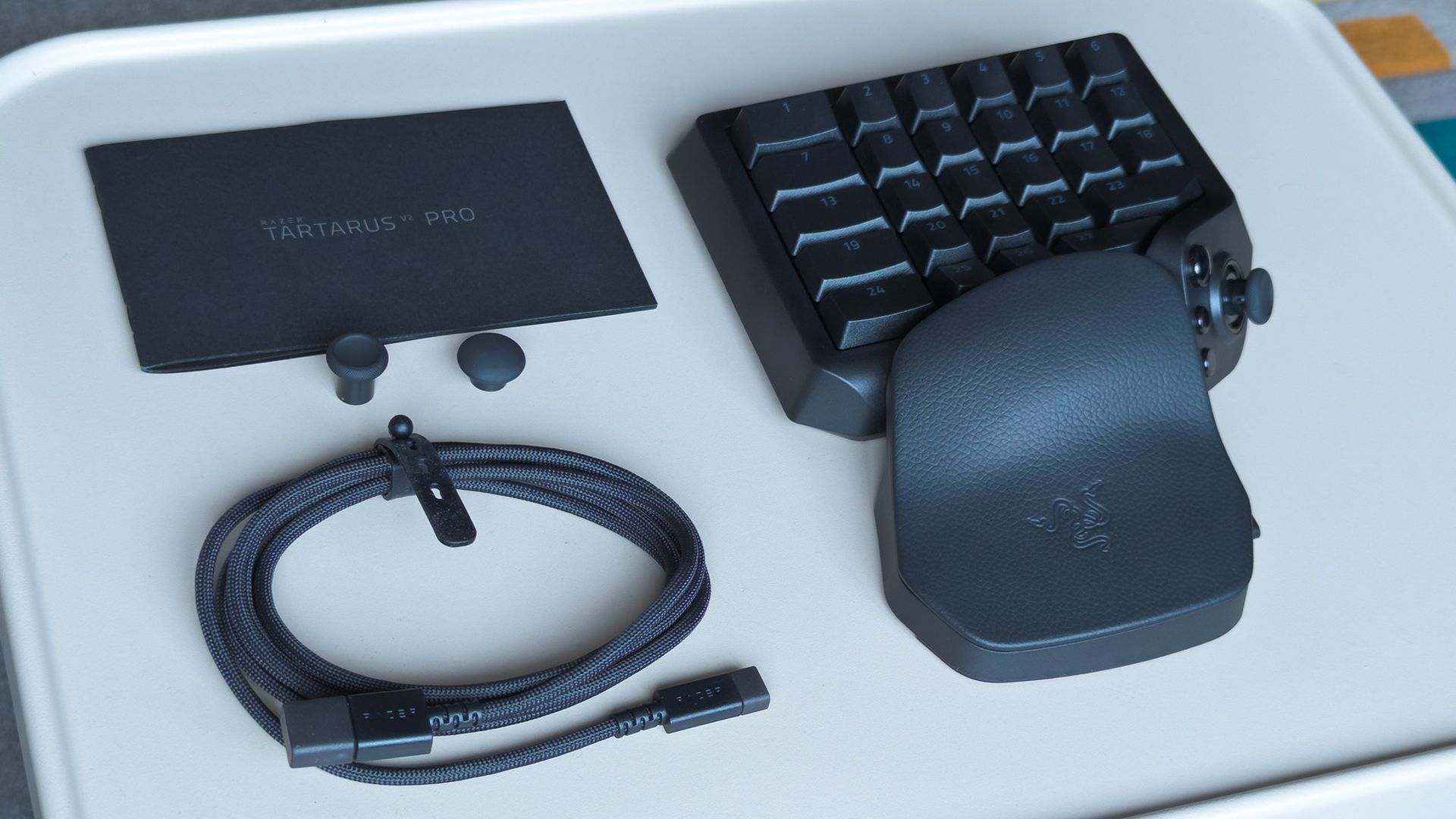 Razer Tartarus V2 Pro box contents displayed on a metal table