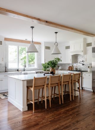 White kitchen with island and rattan seating