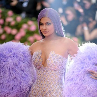 Kylie Jenner wears an all purple outfit to match her purple hair as she walks the red carpet.