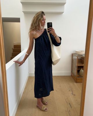 @anoukyve wearing a navy dress and beige slides