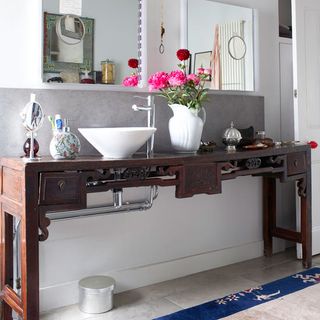 bathroom with table top washbasin and flower vase