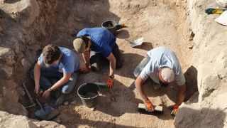 Here we see three archaeologists carefully examining and using brushes to unearth the Salome’s cave and its forecourts excavation site.