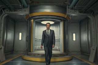walton goggins as cooper howard, standing in an underground vault in front of a circular elevator, in 'Fallout'