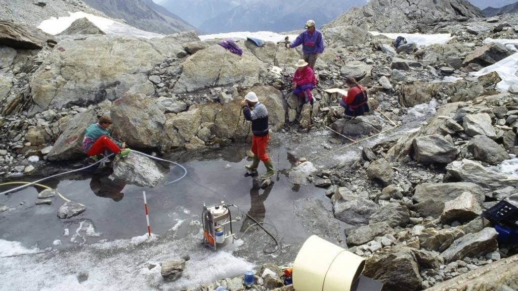 Ozti's upper body was found partially resting on the half-submerged rock on the left of this photograph, where one of the scientific team is resting his green boot.