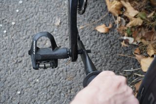Image shows a person using a pedal spanner maintaining their bike on a budget.