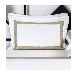 A white sham pillow with a gold border