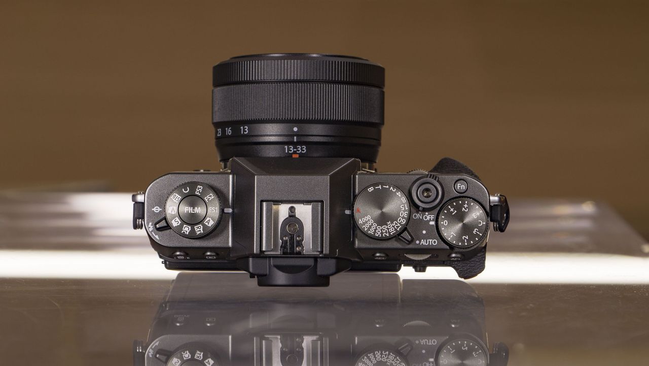 Top of the Fujifilm X-T30 III camera on a glass table