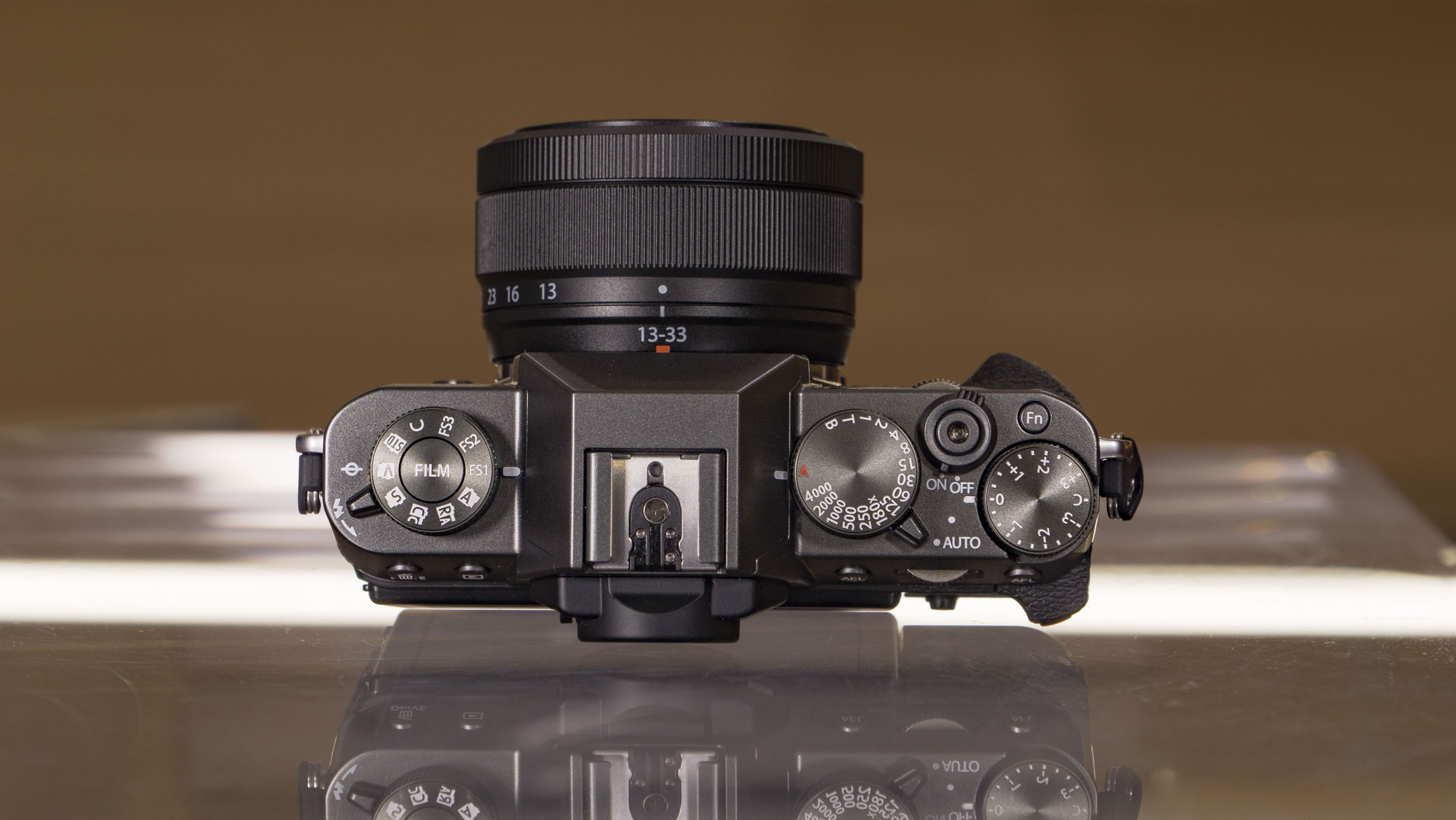 Top of the Fujifilm X-T30 III camera on a glass table