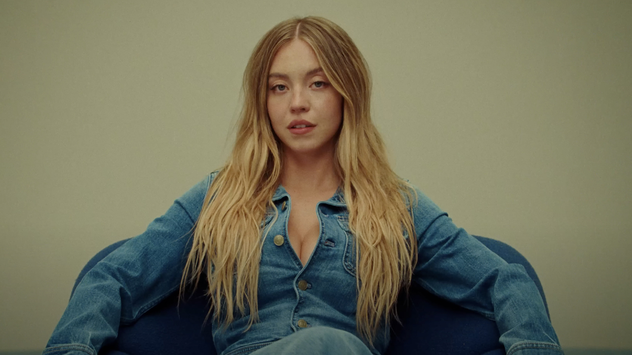 Sydney Sweeney, clad head-to-toe in denim, gazes straight into the camera for American Eagle's "good jeans" ad campaign, which has created controversy. 