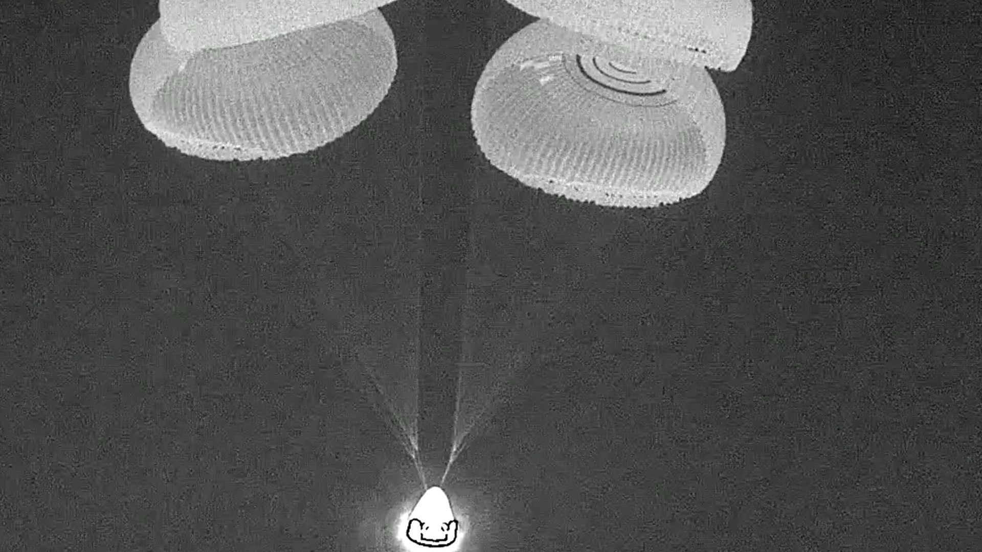 a cone shaped capsule under four parachutes