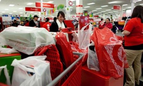 A shopper pays for her purchases during a Black Friday sale at a Target in Braintree, Mass.