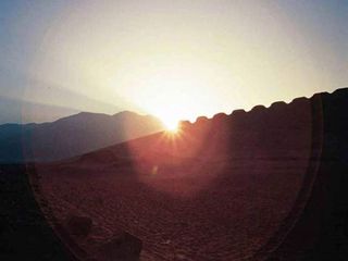 The rise of the sun is seen at a 2,300-year-old structure in Peru during the June solstice in 2003.