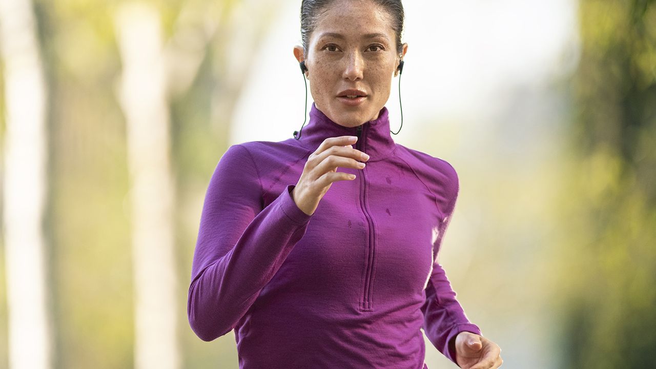 Woman listening to fitness audio apps as she runs