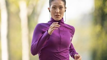 Woman listening to fitness audio apps as she runs