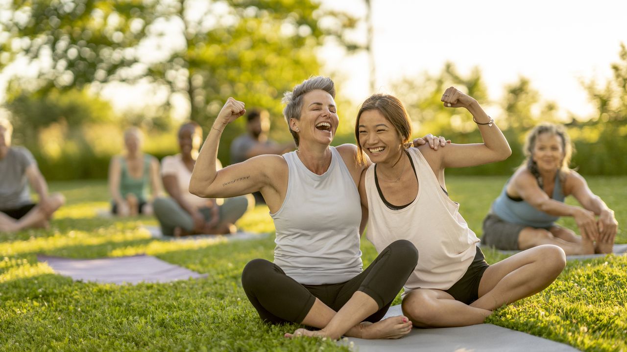 Women smiling doing an outdoor exercise class