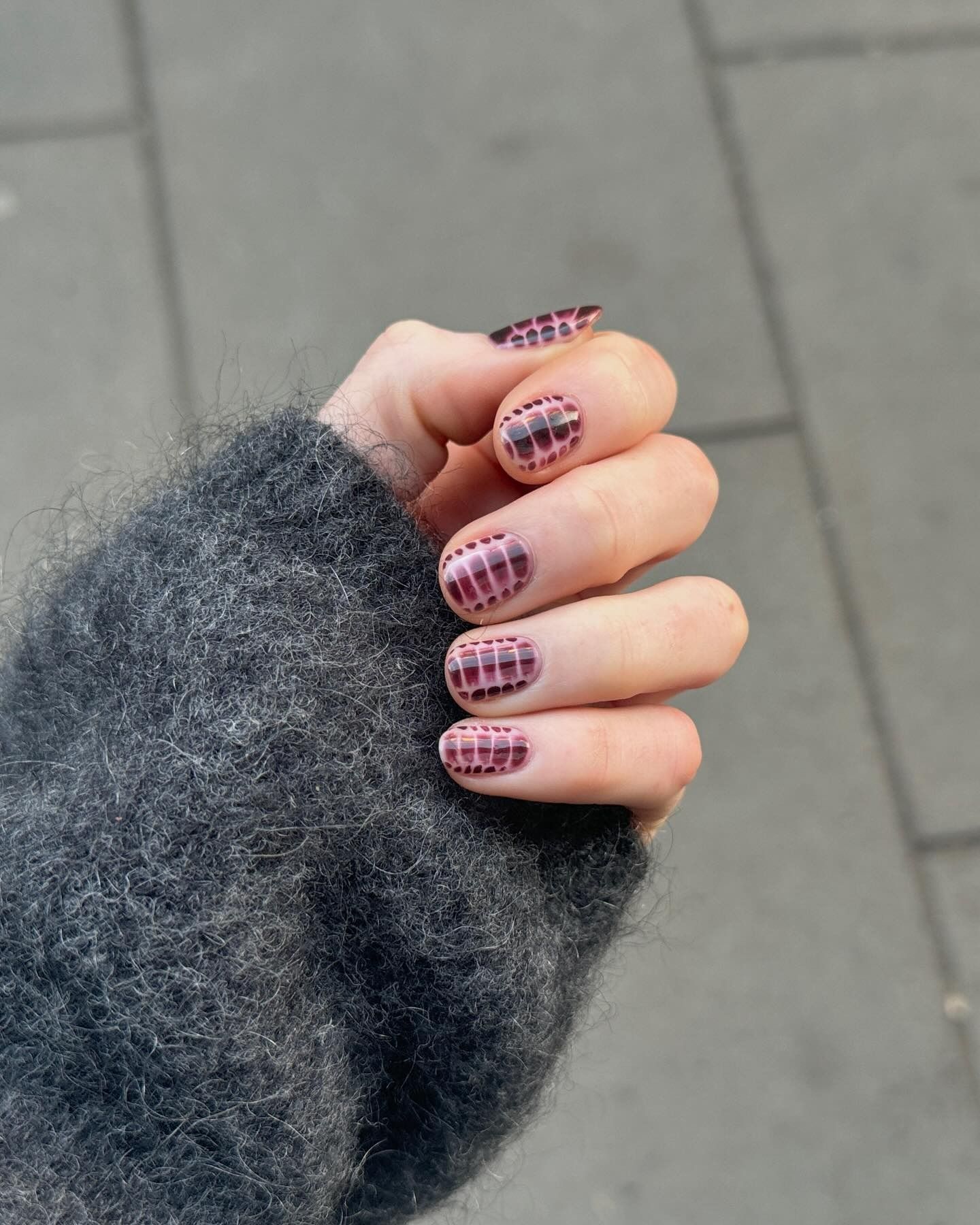 A deep plum croc print manicure