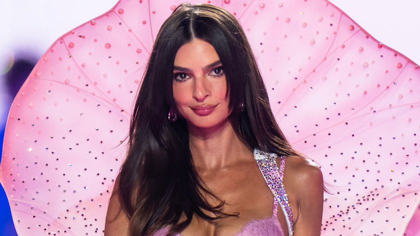 Emily Ratajowki walks the 2025 Victoria&#039;s Secret Fashion show runway in a pink lingerie set with ethereal pink backdrop. 