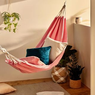 hammock with cushion and pink walls potted plants