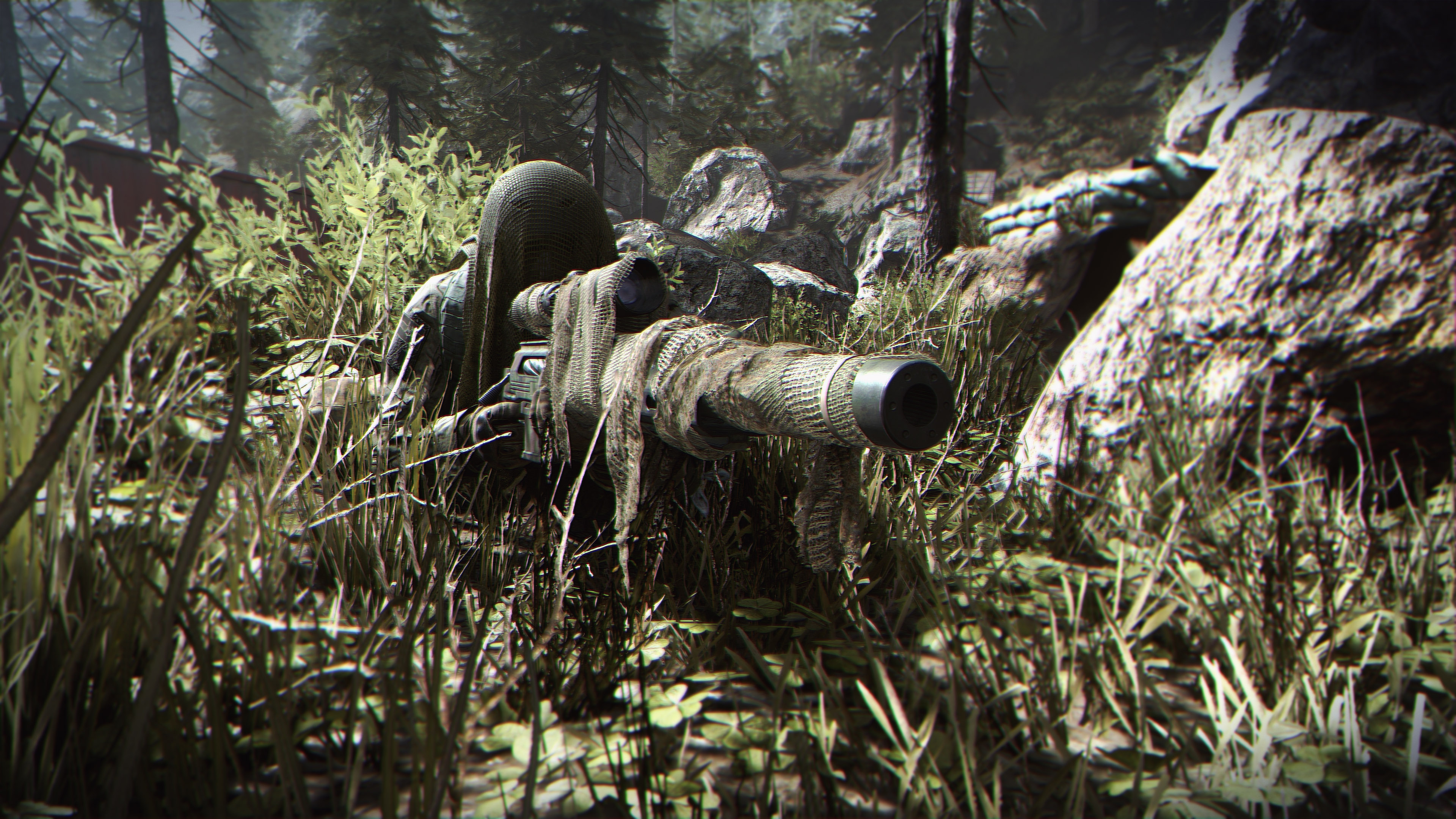 Sniper in a Ghillie suit laying in long grass