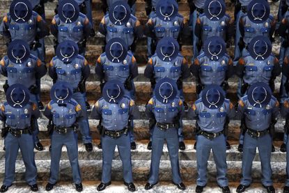 New Washington State Patrol troopers bow their heads during a prayer at the Patrol's graduation ceremonies in the Capitol rotunda in Olympia, Washington.