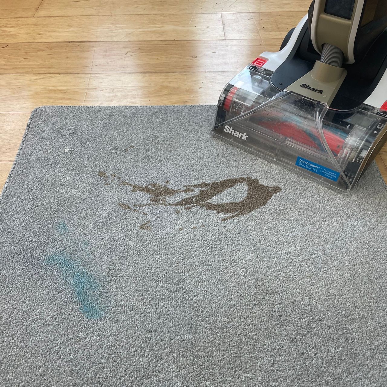 Shark CarpetForce Upright Carpet Cleaner sitting next to grey carpet sample covered in stains