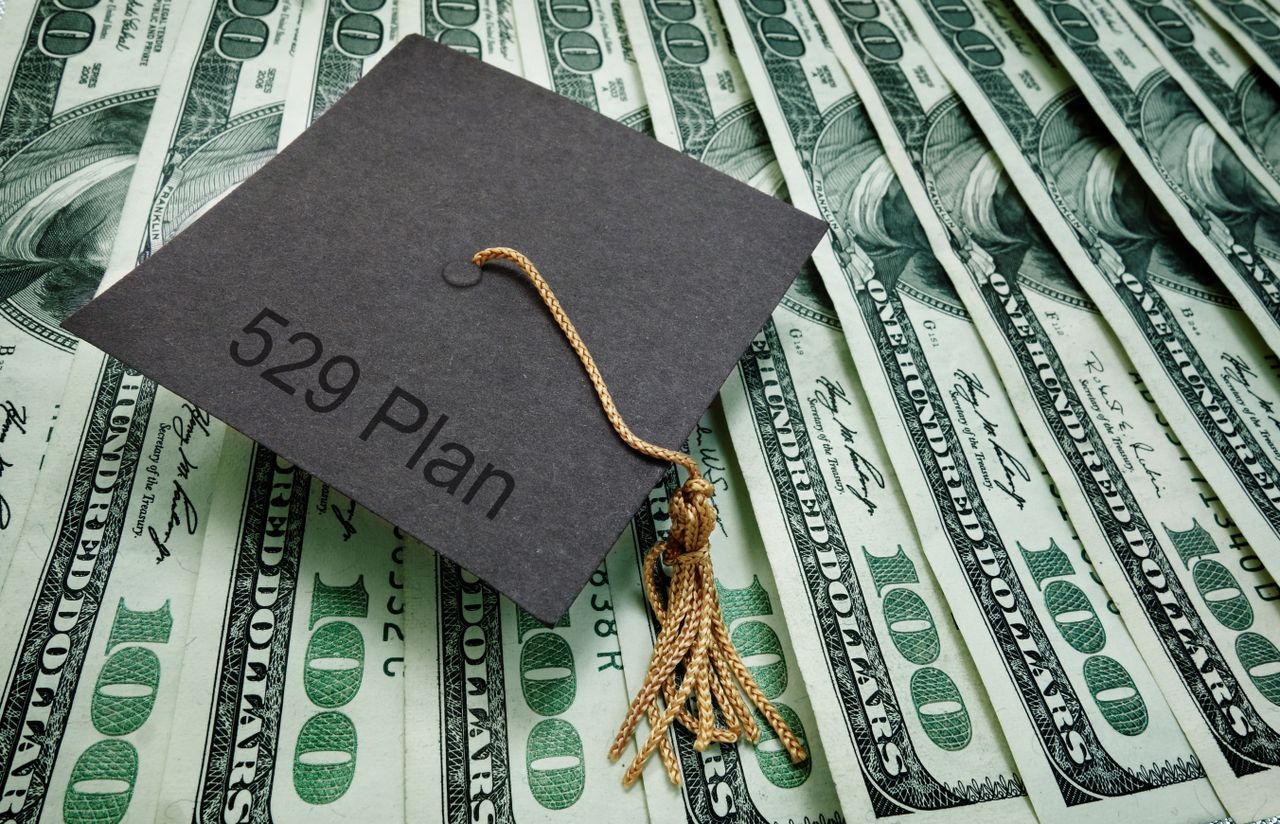 529 plans; 529 Plan is written on a graduation cap resting on a stack of cash. 