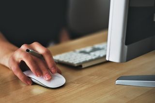 Hand clicking an Apple Mouse