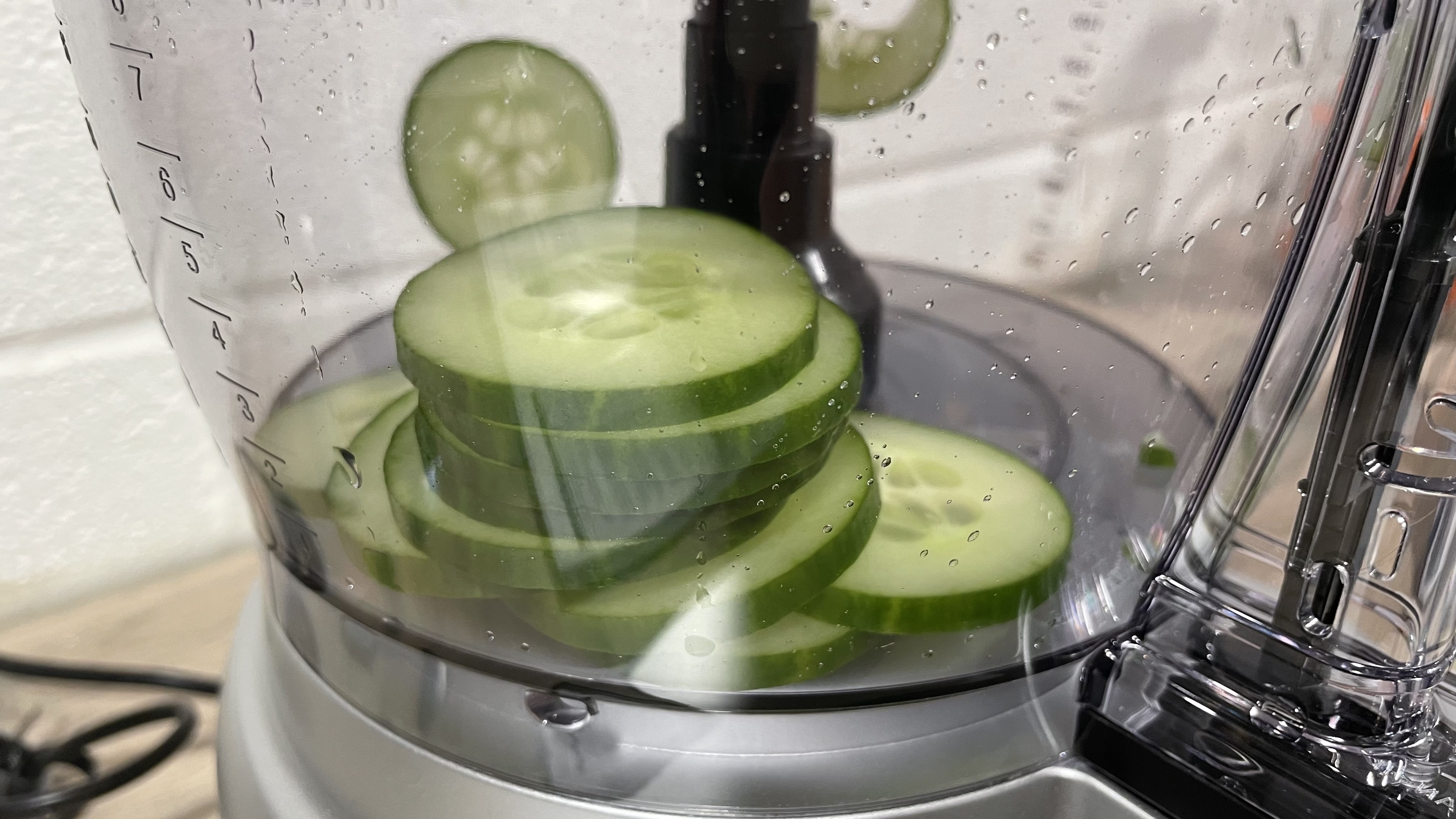 A close up of sliced cucumber inside the Cuisinart Expert Prep Pro large work bowl.