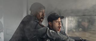 Russell and Travis screaming while driving armored truck with tear gas in the air in The Pickup.