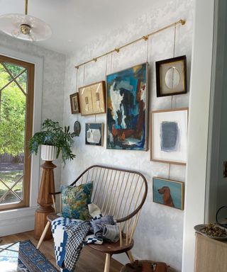 A gold bar hanging, holding a small gallery wall of artwork