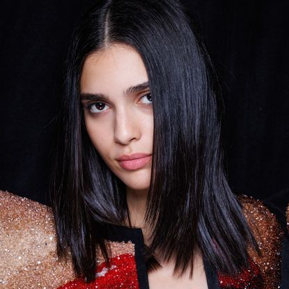 A model with silky straight dark hair, as if she just used a keratin treatment.