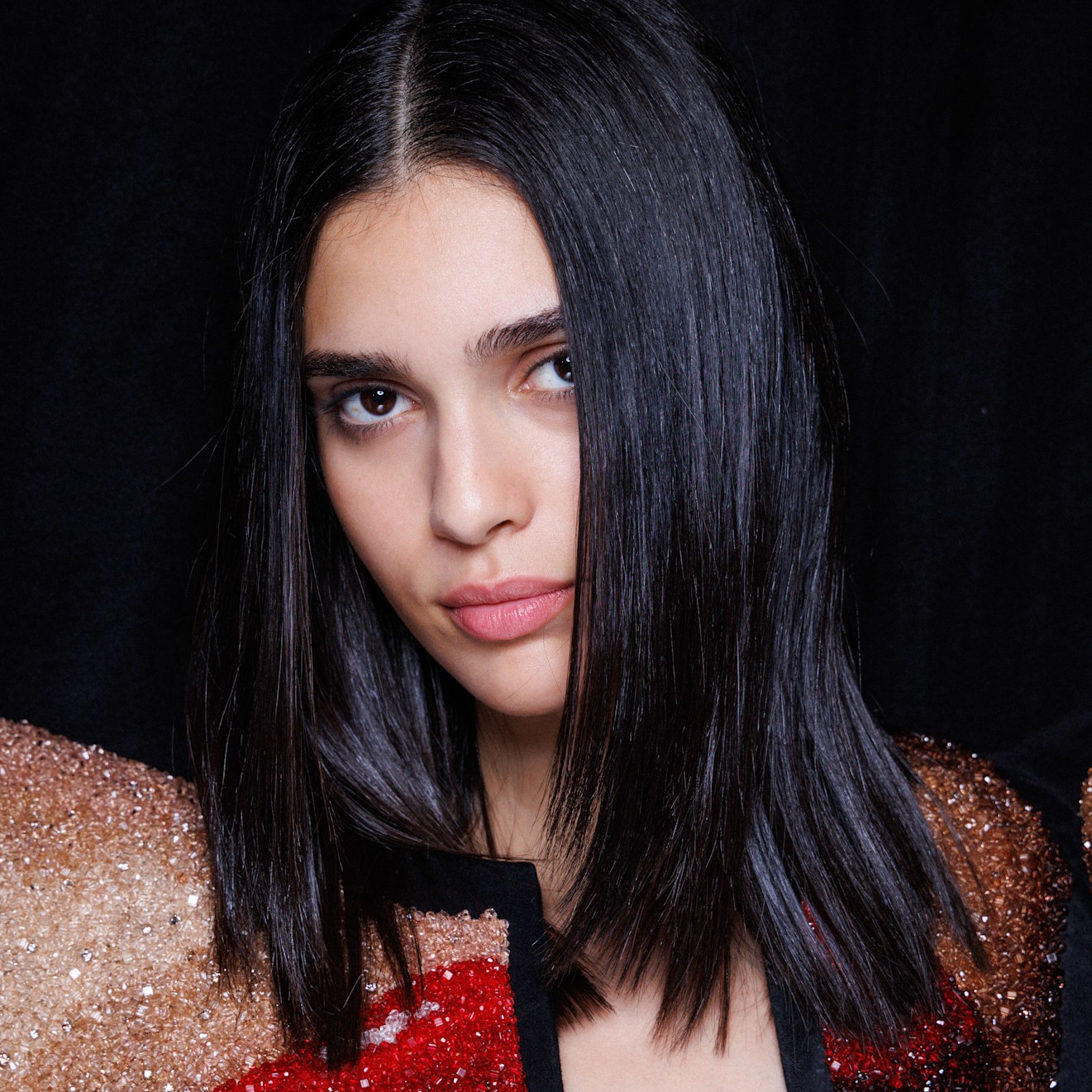 A model with silky straight dark hair, as if she just used a keratin treatment.