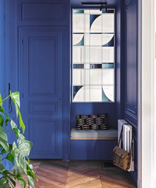Deep navy entryway with seating and stained glass windows